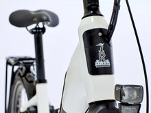 Load image into Gallery viewer, Close-up of a Raleigh ebike with a white frame and black components on a light gray background.