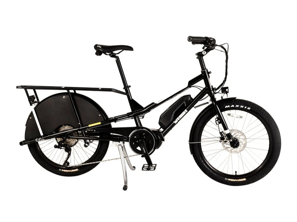 A product image of the Yuba Kombi E6 electric longtail cargo bike. This is the bare layout of the bike, with no accessories added. The bike has a black frame.