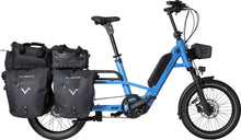 Load image into Gallery viewer, A product image of the Velo de Ville Loady electric longtail cargo bike. The frame colour is blue. Two pairs of carrier bags are attached to the rear rack.