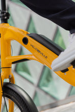 Load image into Gallery viewer, A close-up lifestyle image showing the downtube and battery of a VELO DE VILLE KEB electric bike.