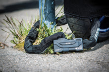 Load image into Gallery viewer, Black chain securing a bike on the ground.