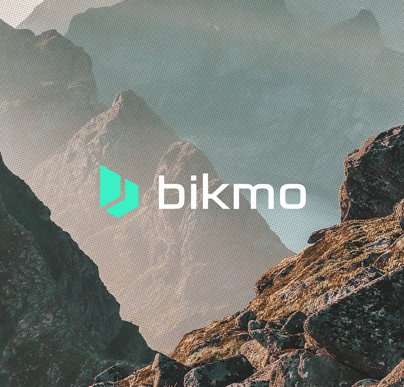 A photo of a scenic mountain setting with the Bikmo logo overlaid in front.