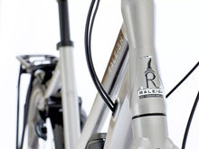 Load image into Gallery viewer, Close-up of a Raleigh bicycle with branding on the frame.
