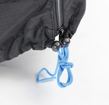 Load image into Gallery viewer, A close-up photo of the zipper end of the Ahooga Transport Cover showing the nylon drawstrings. 
