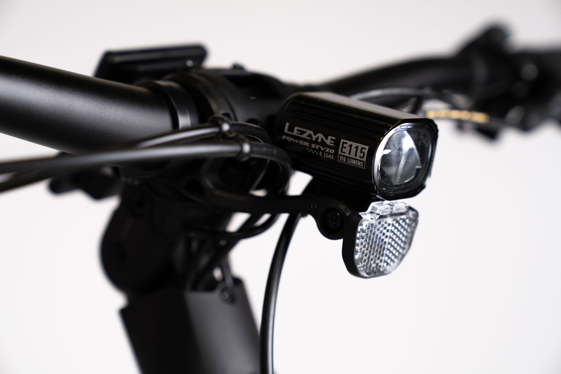 A product image showing a close-up of the Lezyne E115 integrated front light on the BESV CPT 1.4 compact electric bike.