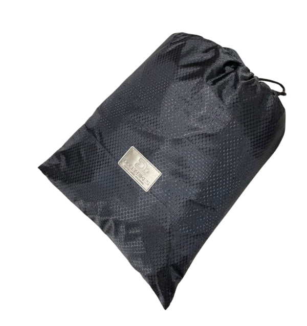 A product image showing the Dolly bike cover packed neatly into its carry bag.