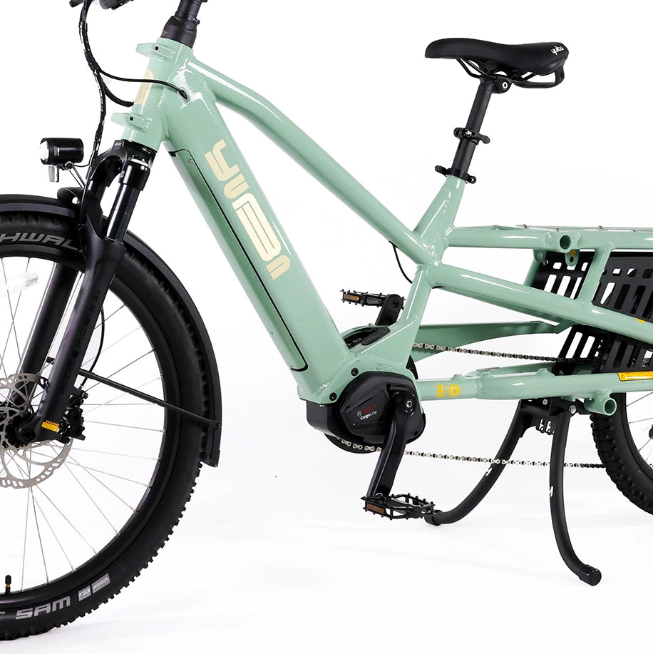 A product image of the Yuba Spicy Curry V4 electric longtail cargo bike. The frame colour is Lunar (a pale green colour) and the bike is in its basic set up, with no accessories attached. 