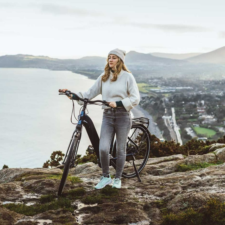 A female model is pictured with a Kuma S2 electric bike on a hill in Killiney overlooking Dublin Bay. 