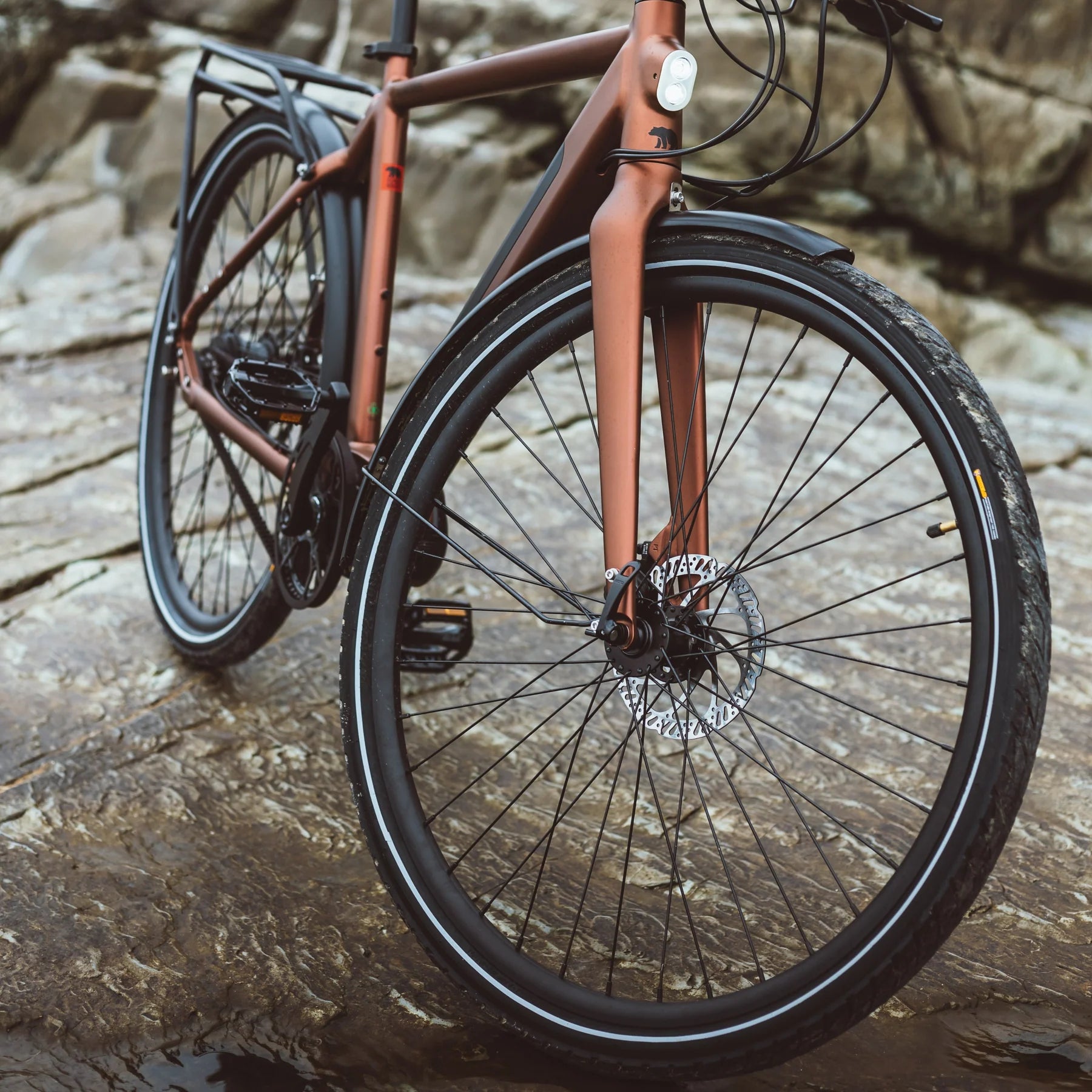 A lifetstyle image of the Kuma M1 electric bike with the bike parked on some bare rocks.