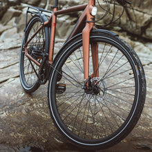 Load image into Gallery viewer, A lifetstyle image of the Kuma M1 electric bike with the bike parked on some bare rocks.
