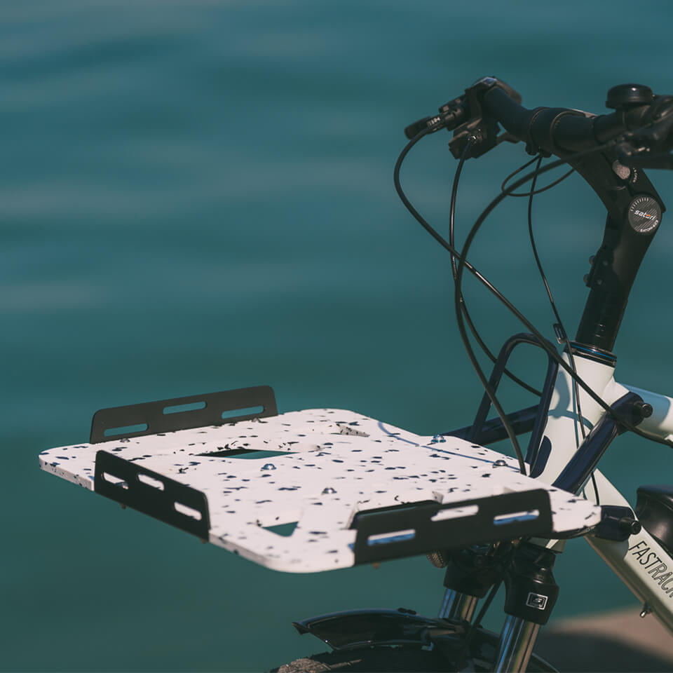 A photo of the Yuba Front Eco Deck attached to the front of a Yuba longtail cargo bike.