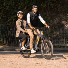 Load image into Gallery viewer, A lifestyle image of the Yuba Compact AlloyBoards accessory for Yuba compact longtail cargo ebikes, showing a rear passenger on a Yuba cargo bike. 
