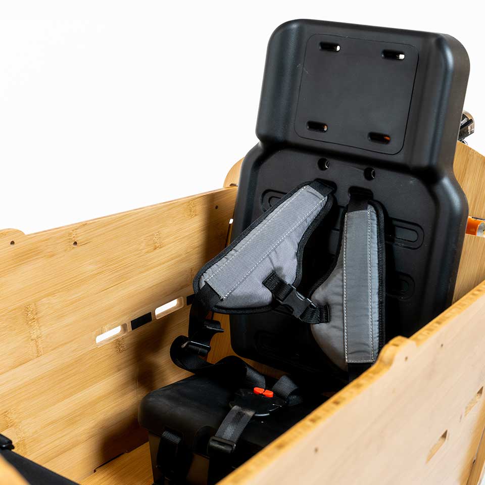 A product image showing the Yuba 2be3 child seat inside the Bamboo Box of the Yuba Supercargo CL electric cargo bike.