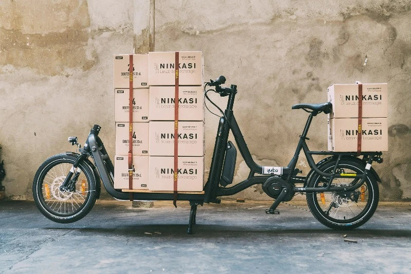 A photo showing a Yuba Supercargo electric cargo bike loaded with boxes which are strapped down with the Yuba Utility Straps.