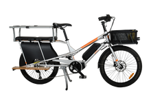 Load image into Gallery viewer, A product image of the Yuba Kombi E5 electric longtail cargo bike which can be hired from LeaseBike. The photo shows the right side of the cargo bike. The photo shows two soft spot seats and a monkey bar accessory attached to the rear rack and a bread basket attached to the front of the bike.
