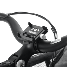 Load image into Gallery viewer, Product image of a Yuba Phone Holder in position on the handlebars or a Yuba bike, without a phone attached. 
