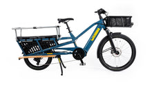 Load image into Gallery viewer, A product image of the Yuba Spicy Curry V4 electric longtail cargo bike. The frame colour is True Blue and the bike has a monkey bar add-on on the rear and a bread basket on the front.
