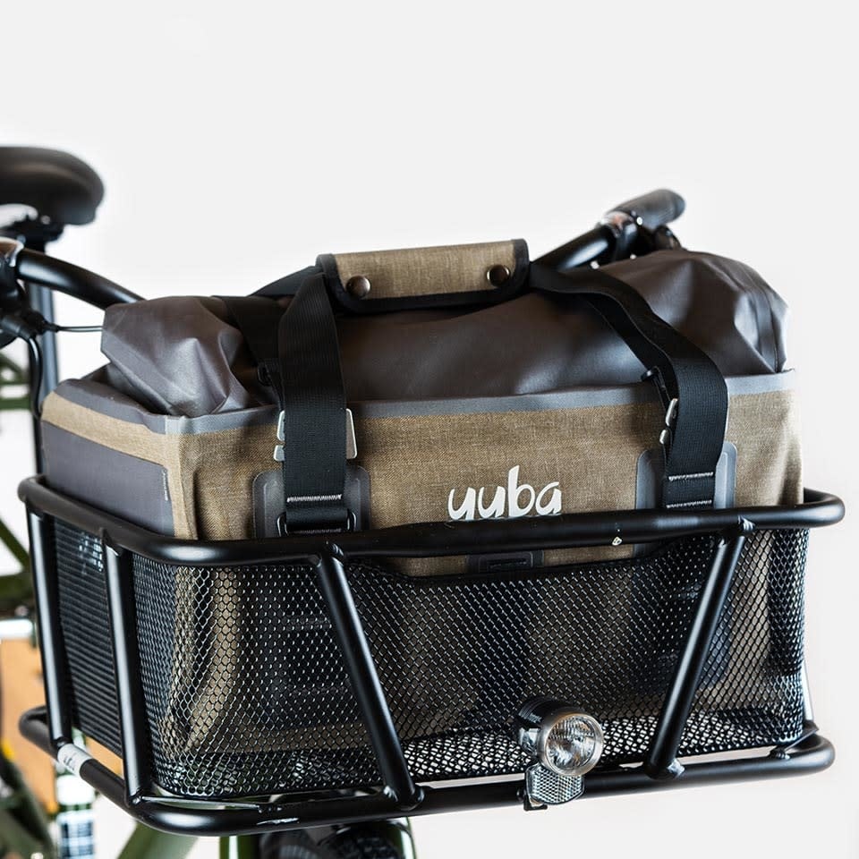 A product image for the Yuba Grab and Go bag sitting in the front basket of a Yuba longtail cargo bike.