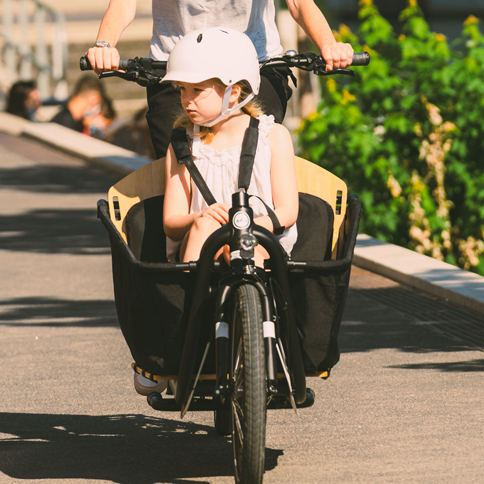 A lifestyle image of the Yuba Open Loader Seat Kit for the Yuba Supercargo CL electric cargo bike.