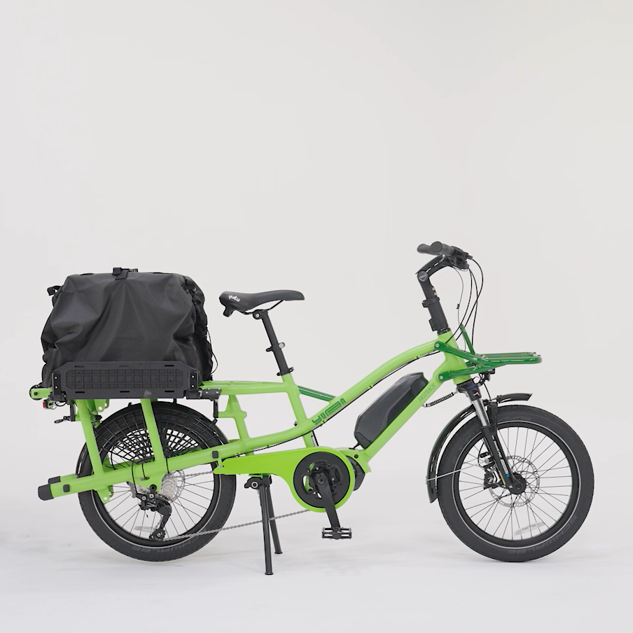 A product picture of the Yuba DRS Bags attached to the rear carrier of the Yuba Fastrack electric longtail cargo bike. This photo shows the bags in the 'High' position.